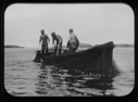 Image of Three men in dory work with nets
